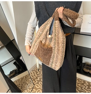 Detail showing plush striped knit tote bag with brown pocket and blue plaid lining detail