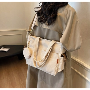 Detail view of cream corduroy tote bag with side pockets and a matching round coin purse