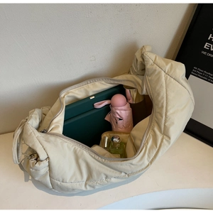 Interior view showing large capacity for tablet, umbrella and cosmetics in cream puffer bag