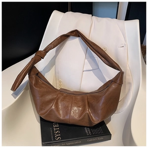 Detailed macro view of the knotted shoulder strap and soft brown pleated leather texture