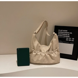 Detail der beigen Falten-Schultertasche mit verstellbarem Gurt und großem Innenraum