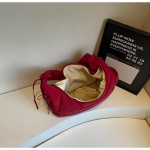 Detail showing inner beige lining and pocket of the magenta quilted nylon puffer bag