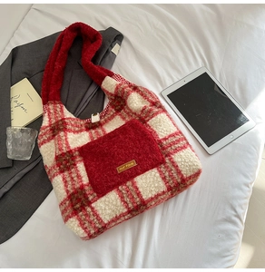 Detailed view of red and white plaid plush tote bag with fuzzy texture and decorative label