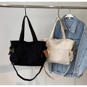 Detail of corduroy tote bags with external pockets and small round coin purse charms