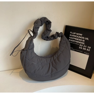 Detail of dark grey quilted moon bag showing the soft padded fabric and ruched handle