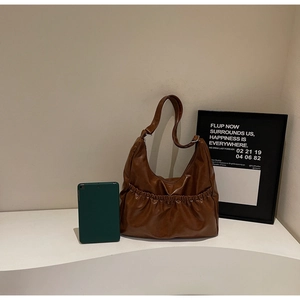 Makro-Detail braune Leder-Hobo-Tasche mit ästhetischer Falten-Tasche und weicher Textur
