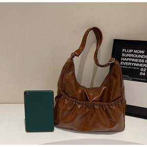 Detailansicht der braunen PU-Leder Schultertasche mit Falten und silberner Schnalle