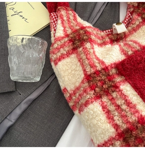 Close-up of red and white plaid plush tote bag with soft fleece texture and snap button