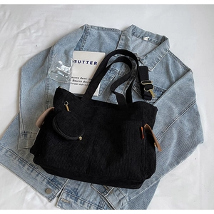 Detail of black corduroy tote bag with mini coin purse and adjustable shoulder strap