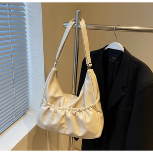 Detailansicht der Hobo-Tasche aus cremefarbenem PU-Leder mit Falten-Design und Schultergurt