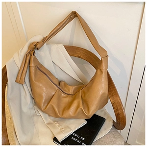 Detail of a brown pleated hobo bag featuring a unique knotted shoulder strap and soft PU texture