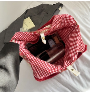 Top view of spacious interior of red plush tote bag with festive red and white plaid lining