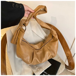 Detailed close-up of a khaki pleated hobo bag featuring a knotted wide shoulder strap