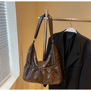 Detailansicht der dunkelbraunen Retro-Faltentasche aus hochglänzendem Vintage-Leder