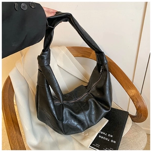 Detail of knot shoulder strap and premium leather texture on black Hobo bag
