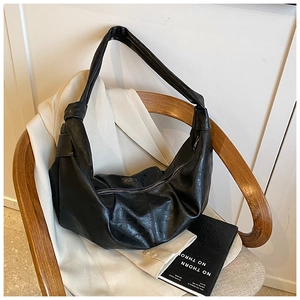 Detail view of the black retro pleated leather hobo bag with a stylish knotted strap design