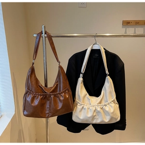 Detailansicht großer Halbmond-Schultertaschen in Braun und Beige mit Falten-Vordertaschen