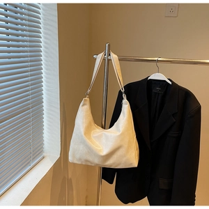 Detail der beige plissierten Hobo-Tasche mit glatter PU-Textur und breitem Gurt