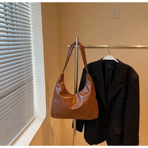 Detailansicht der braunen Kunstleder-Hobo-Tasche mit Falten in schicker Halbmondform