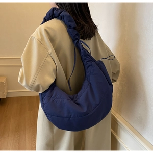 Detailed side view of the quilted navy moon bag featuring a unique gathered drawstring strap