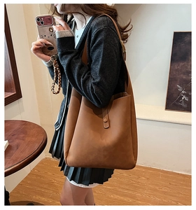 Detail view of brown matte faux suede tote bag showing texture and magnetic clasp