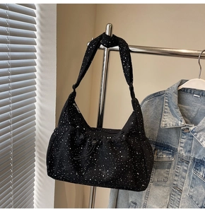Detail of black crescent shoulder bag with white star print and pleated nylon texture