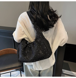 Detailed view of black nylon crossbody bag with white dots on a model back view