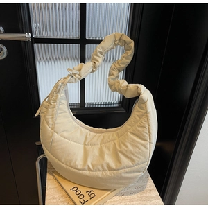 Detail of creamy white quilted moon bag with stylish scrunchie shoulder strap design