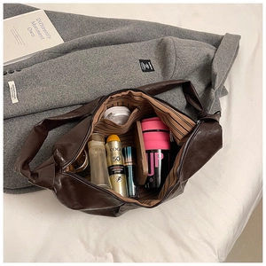 Detailed interior of a spacious brown soft leather tote bag showing large storage capacity