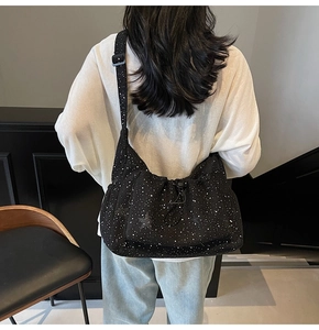 Detail of black nylon crossbody bag with white starlight texture and drawstring pocket