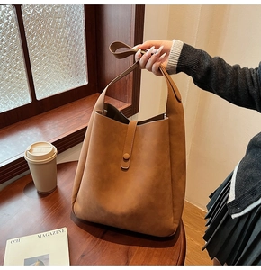 Close-up of caramel brown tote bag featuring matte texture and magnetic strap detail
