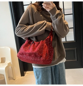 Detail of red corduroy crossbody bag with white dots and drawstring closure