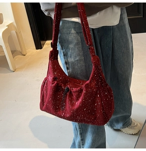 Detail of dark red corduroy crossbody bag with white dots and drawstring pocket design
