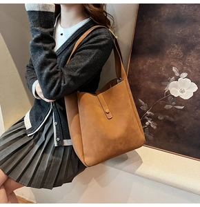 Detail view of brown leather Hobo shoulder bag with gold metal buckle closure