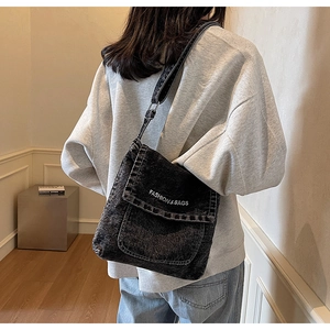 Dettaglio della borsa a tracolla in denim nero lavato con stampa logo Fashion & Bags bianca