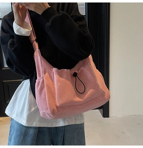 Detail of pink corduroy crossbody bag with sequins and adjustable drawstring pocket