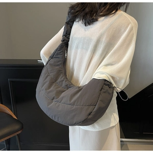 Side view of oversized dark grey quilted moon bag showing large capacity on model
