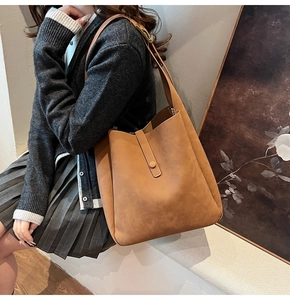 Detailed macro view of the caramel brown tote bag featuring matte texture and vertical strap