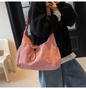 Pink corduroy shoulder bag with splash ink pattern and side drawstring pocket detail