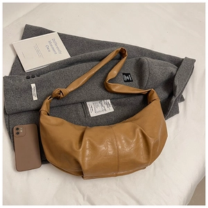 Detail of soft brown pleated leather crescent bag with stylish knot strap design