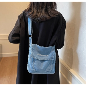 Dettaglio della borsa a tracolla in denim blu con stampa FASHION & BAGS e tracolla regolabile