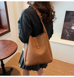 Detail of caramel matte leather shoulder bag with adjustable golden metal buckle and strap