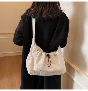 Detail of off-white corduroy tote bag with silver sequins and drawstring closure
