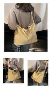 Detail view of a large canvas tote bag showing the shoulder strap and minimalist design