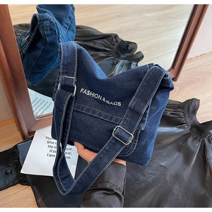 Dettaglio borsa a tracolla in denim blu scuro con ricamo e cinghia regolabile ampia