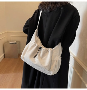 Detail of off-white corduroy shoulder bag with sequins and black drawstring closure