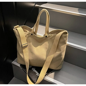 Detail of khaki canvas tote bag showing thick fabric texture and sturdy shoulder strap