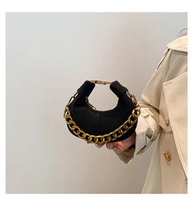 Detalle de bolso hobo de ante negro con cadena dorada gruesa y cierre metálico fino