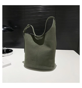 Detail view of large olive green suede hobo bucket bag with an adjustable wide strap