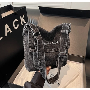 Dettaglio della borsa a tracolla in denim nero lavato con fibbia in metallo argento regolabile